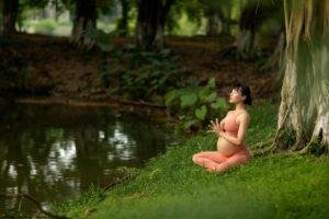 Pregnant woman meditation by the water